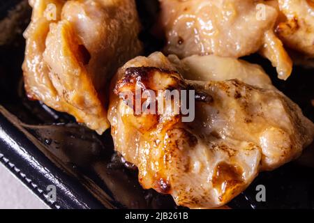 Un pollo giapponese teriyaki da asporto in un contenitore. Teriyaki è una tecnica di cottura in cui gli alimenti vengono grigliati con una salsa di soia, mirina e zucchero Foto Stock