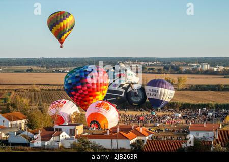 Coruche, Portogallo - 13 novembre 2021: Vista di mongolfiere pronti a decollo e un altro mongolfiera già in aria. Foto Stock