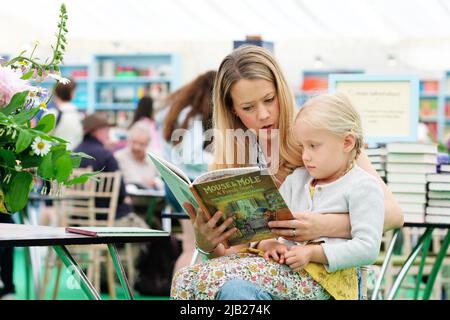 Hay Festival, Hay on Wye, Wales, UK – Giovedì 2nd Giugno 2022 – Un visitatore di Hay legge a un bambino nella libreria del Festival tra gli eventi durante l'ottavo giorno di quest'anno Hay Festival – Foto Steven Maggio / Alamy Live News Foto Stock