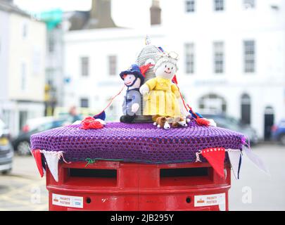 Bicester, Oxfordshire, Regno Unito. 2nd giugno 2022. Le nazioni del Regno Unito iniziano un fine settimana di 4 giorni per celebrare il Giubileo del platino della Regina. NELLA FOTO: Il centro di Bicester celebra. Figure accovacciate di HM la Regina (con il suo corgo) più un poliziotto in uniforme tradizionale in cima a una casella postale. Credit: Bridget Catterall/Alamy Live News. Foto Stock