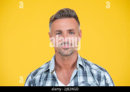 uomo maturo sorridente con capelli grizzle su sfondo giallo Foto Stock