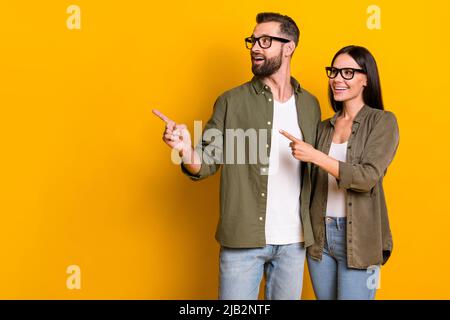 Foto di bruna millennial impressa indice persone look promo indossare occhiali camicia isolato su sfondo giallo Foto Stock