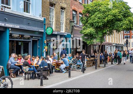 Persone seduti fuori mangiare e bere a Exmouth Market, Clerkenwell, Londra EC1 Foto Stock