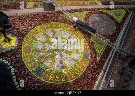 Dirigiti verso il giardiniere David Dorward accanto al design di quest'anno sull'orologio floreale più antico del mondo nei West Princes Street Gardens di Edimburgo, il giorno uno dei festeggiamenti del Platinum Jubilee. Data foto: Giovedì 2 giugno 2022. Foto Stock