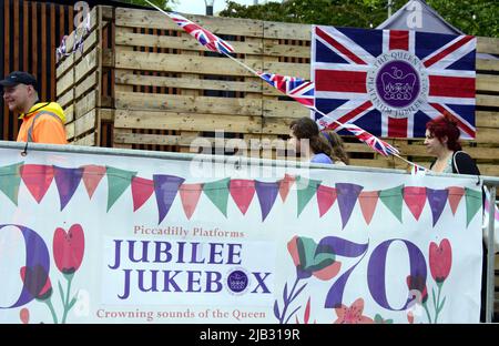 Manchester, Regno Unito, 2nd giugno 2022. La gente cammina davanti a una piattaforma "Jubilee Jukebox" a Piccadilly Gardens, Manchester, Regno Unito. Decorazioni a Manchester, Inghilterra, Regno Unito, Isole britanniche per celebrare il Giubileo del platino della Regina 2022. La Regina Elisabetta II è il primo monarca britannico a celebrare un Giubileo del platino dopo 70 anni. Il Platinum Jubilee si svolge dal 2nd al 5th giugno. Venerdì 3rd giugno è un giorno festivo extra, che si traduce in un week-end di quattro giorni. Credit: Terry Waller/Alamy Live News Foto Stock
