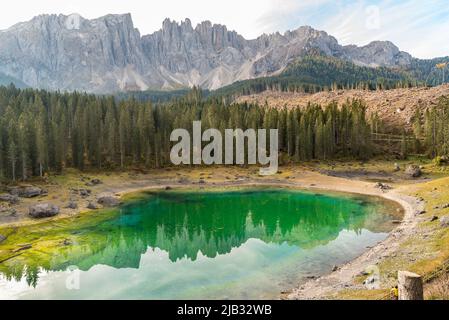 Vista su un piccolo lago alpino Carezza o Karersee situato a Nova Levante, provincia di Bolzano in Dolomiti, Alto Adige, Italia Foto Stock
