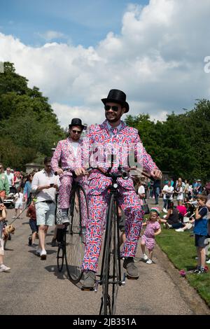 Windsor, Berkshire, Regno Unito. 2nd giugno 2022. Due uomini ciclano in modo casuale lungo la passeggiata lungo Penny Farthing biciclette e indossare Union Jack abiti. Migliaia di persone sono andati al Long Walk oggi per fare un picnic, celebrare e guardare le frecce rosse flypassato. Windsor è stata piena di gente del posto, turisti e visitatori che oggi celebrano il Giubileo del platino di sua Maestà la Regina. Credit: Maureen McLean/Alamy Live News Foto Stock