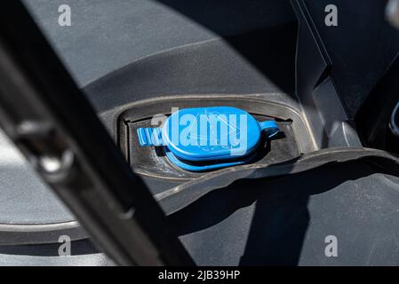 Serbatoio liquido lavacristallo con tappo blu, situato nel vano motore. Foto Stock