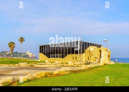 Tel-Aviv, Israele - 26 maggio 2022: Vista del Museo Etzel edificio, sulla costa, con i pedoni e la vecchia Jaffa sullo sfondo. Tel-Aviv, Israele Foto Stock