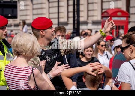 I membri della Royal Military Police (RMP) assistono il pubblico nell'accesso al Mall per guardare il Trooping of the Color che ha coinciso con il Giubileo del platino della regina, il 1st giugno 2022 a Londra, Inghilterra. La regina Elisabetta II è stata sul trono britannico per 70 anni, il monarca che serve più a lungo nella storia inglese e la folla si è bloccata nel centro di Londra per vedere questo evento annuale durante il fine settimana del Giubileo. Decine di migliaia, tuttavia, non sono stati in grado di vedere alcuna delle cerimonie di pageantry perché il Mall è stato chiuso a più del pubblico dalla polizia, rimanendo invece intorno alle strade circostanti e a Trafalgar Foto Stock