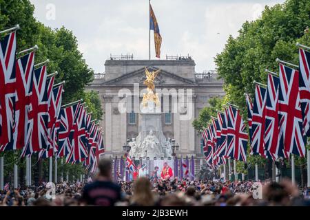 Vista di Buckingham Palace dal Mall e dalla Royal Family camminando sul balcone mostrato sullo schermo Foto Stock