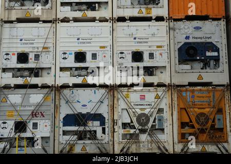 Vista sui contenitori di colore bianco e arancione da vari caricatori dal lato del motore e del compressore fissati e fissati sul ponte del contenitore. Foto Stock