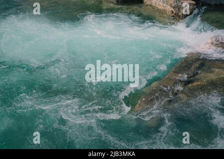 onde che si infrangono sulle rocce, acque cristalline del mare smeraldo. moto fluviale, potere della natura, kayak, bella texture naturale del mare Foto Stock