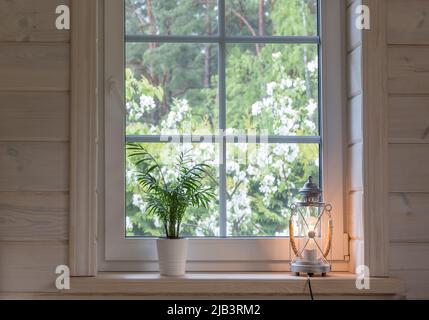 Finestra bianca con rete di mosuito in una casa rustica in legno Foto Stock