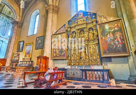 COMO, ITALIA - 20 MARZO 2022: La pala d'altare ornata intagliata e dipinta nella cappella della Cattedrale di Santa Maria Assunta, il 20 marzo a Como Foto Stock