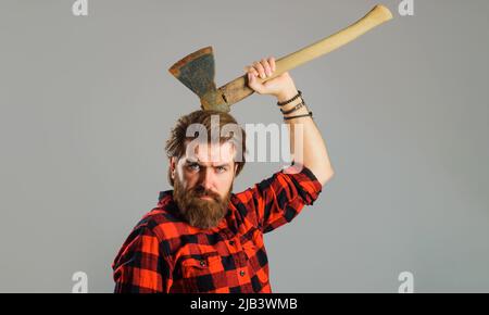 Uomo portato in camicia a quadri con ascia. Strumenti di registrazione. Taglio del legno. Grumberjack canadese con hatchet. Foto Stock