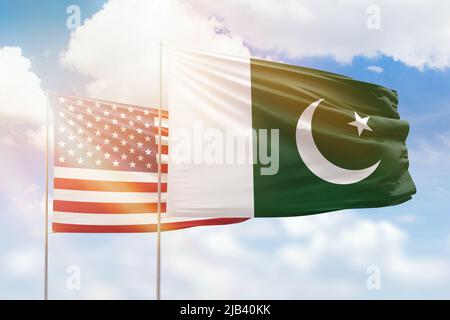 Cielo azzurro soleggiato e bandiere di pakistan e stati uniti Foto Stock