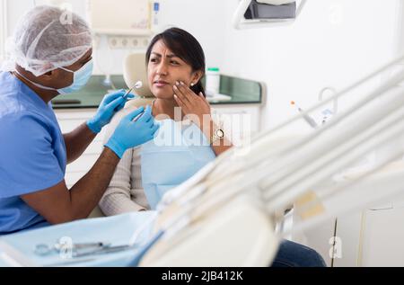 Medico professionista che parla con il paziente in sedia Foto Stock