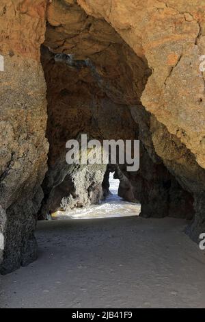 Tunnel naturale che attraversa una grande roccia Praia Tres Castelos Beach. Portimao-Portogallo-289 Foto Stock