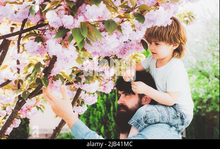 Giorno dei padri. Padre con Figlio che si diverti nel parco. Ragazzo con padre che si divertono insieme nel parco. Padre e figlio giocano nel parco durante il giorno. Foto Stock