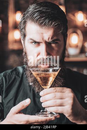 Barman con martini o liquore. Uomo porticato vestito e bere alcol. Concetto di drink e festa di festa. Degustazione e degustazione. Foto Stock