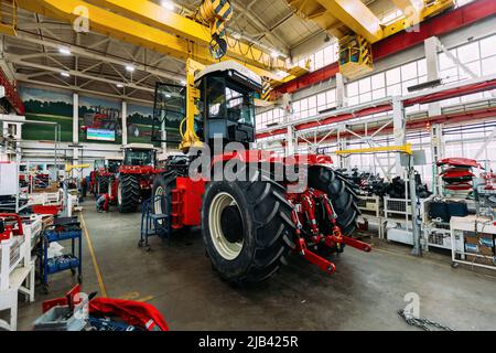 Processo di montaggio dei trattori agricoli in officina industriale. Foto Stock