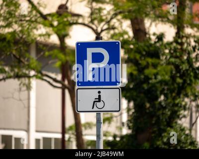 Cartello stradale per parcheggio accessibile con sedia a rotelle. Simbolo di strada con sedia a rotelle. Posto extra per parcheggiare un'auto per persone disabili. Foto Stock