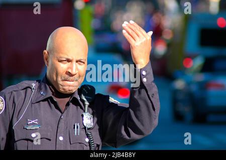 Mano ufficiale di polizia che dirige il traffico per andare o fermarsi ad Atlanta GA, uomo nero, alcuni su moto bicicletta Foto Stock