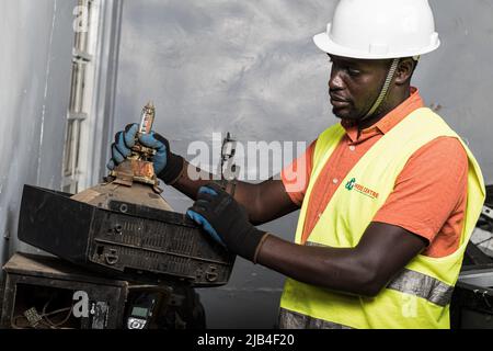 Mark Oluoch un addetto ai rifiuti elettronici con Waste Electrical and Electronic Equipment Center (WEEE Center) smista i rifiuti elettronici presso un centro di raccolta dei rifiuti elettronici a Nakuru prima che vengano successivamente trasportati a Nairobi per il riciclaggio. Il Kenya genera circa 11.000 tonnellate metriche di rifiuti elettronici ogni anno, la maggior parte di questi rifiuti contiene sostanze chimiche dannose come piombo, mercurio e fosforo. Si chiede di aumentare i tassi di raccolta e di riciclaggio dei rifiuti elettronici e plastici per salvaguardare l'ambiente e la salute pubblica. Foto Stock