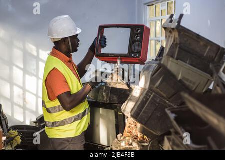 Mark Oluoch un addetto ai rifiuti elettronici con Waste Electrical and Electronic Equipment Center (WEEE Center) smista i rifiuti elettronici presso un centro di raccolta dei rifiuti elettronici a Nakuru prima che vengano successivamente trasportati a Nairobi per il riciclaggio. Il Kenya genera circa 11.000 tonnellate metriche di rifiuti elettronici ogni anno, la maggior parte di questi rifiuti contiene sostanze chimiche dannose come piombo, mercurio e fosforo. Si chiede di aumentare i tassi di raccolta e di riciclaggio dei rifiuti elettronici e plastici per salvaguardare l'ambiente e la salute pubblica. (Foto di James Wakibia/SOPA Images/Sipa USA) Foto Stock