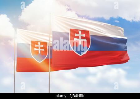 Cielo azzurro soleggiato e bandiere di slovacchia e slovacchia Foto Stock
