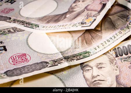Primo piano di un paio di banconote giapponesi da 10000 yen sul tavolo. Foto Stock