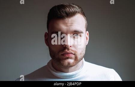 Barbiere per capelli. Uomo beared macho ravvicinato faccia in su. Concetto di barbiere. Cura della barba. Barba stile hipster. Bel ragazzo sopportato. Mascolinità e. Foto Stock