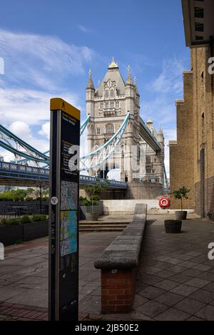 LONDRA, UK - 01 GIUGNO 2022: Ufficio informazioni turistiche con indicazioni per Tower Bridge e vista sul Tower Bridge sullo sfondo Foto Stock