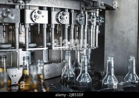 L'apparecchiatura automatica mette i tappi sulle bottiglie di bevande alcoliche Foto Stock