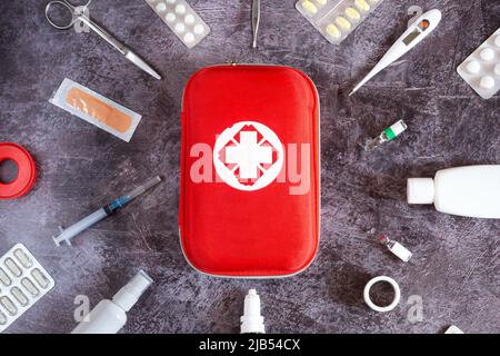 Home kit di pronto soccorso, pillole, termometro su sfondo semplice Foto Stock