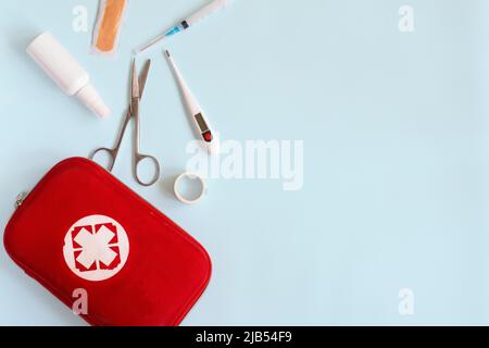 Home kit di pronto soccorso, pillole, termometro su sfondo semplice Foto Stock