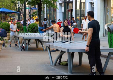 La gente gioca a ping pong in Plaza 33 spazio pubblico vicino a Herald Square a New York, NY, 30 maggio 2022. Cornilleau Park tavoli da ping pong all'aperto. Foto Stock