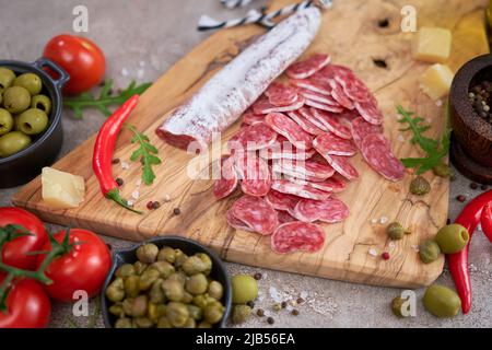 Affettato salsiccia spagnola fuet salame e verdure su una cucina domestica Foto Stock