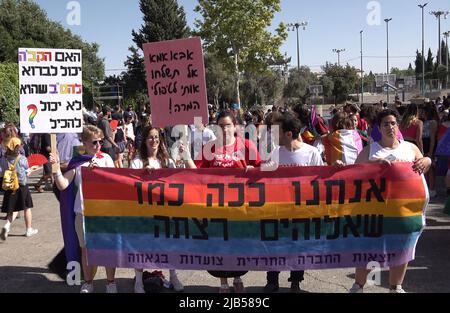 GERUSALEMME, ISRAELE - GIUGNO 02: Membri della LGBT che hanno lasciato una comunità ebraica ortodossa, Tenere la bandiera tradizionale arcobaleno gay orgoglio con una scrittura in ebraico 'Siamo il modo in cui Dio ha voluto che siamo' durante l'annuale parata di Gerusalemme Gay Pride come parte dell'osservanza internazionale del mese LGBT Pride il June0 2, 2022 a Gerusalemme, Israele. La Parata del Gay Pride di Gerusalemme incontra spesso contro-proteste lungo il suo percorso, e occasionalmente con violenza. I leader della comunità Haredi e di altri gruppi religiosi chiedono ogni anno la sua cancellazione. Credit: Eddie Gerald/Alamy Live News Foto Stock