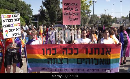 GERUSALEMME, ISRAELE - GIUGNO 02: Membri della LGBT che hanno lasciato una comunità ebraica ortodossa, Tenere la bandiera tradizionale arcobaleno gay orgoglio con una scrittura in ebraico 'Siamo il modo in cui Dio ha voluto che siamo' durante l'annuale parata di Gerusalemme Gay Pride come parte dell'osservanza internazionale del mese LGBT Pride il June0 2, 2022 a Gerusalemme, Israele. La Parata del Gay Pride di Gerusalemme incontra spesso contro-proteste lungo il suo percorso, e occasionalmente con violenza. I leader della comunità Haredi e di altri gruppi religiosi chiedono ogni anno la sua cancellazione. Credit: Eddie Gerald/Alamy Live News Foto Stock