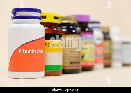 Vitamina D3 e altre vitamine su sfondo beige. Supplementi dietetici per le persone Foto Stock