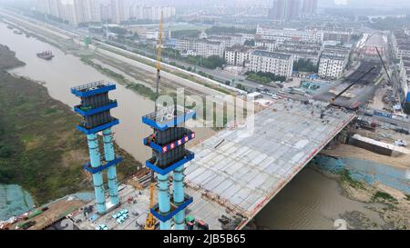 (220603) -- HEFEI, 3 giugno 2022 (Xinhua) -- La foto aerea scattata il 3 giugno 2022 mostra i costruttori che lavorano nel cantiere di un ponte, che fa parte di un mega progetto di diversione dell'acqua per deviare l'acqua dal fiume Yangtze al fiume Huaihe, nella provincia di Anhui nella Cina orientale. (Xinhua/Liu Junxi) Foto Stock