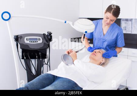 Cosmetico esame della pelle del viso di donna matura Foto Stock