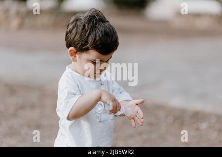 Il bambino si lava le mani con il gel igienizzante per le mani. Foto Stock