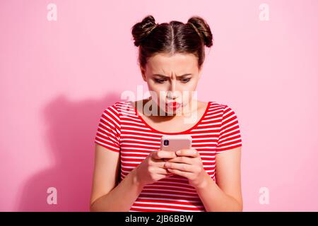 Foto di infelice signora sconvolto vestito t-shirt a righe gonfio guance che battono moderno dispositivo isolato colore rosa sfondo Foto Stock