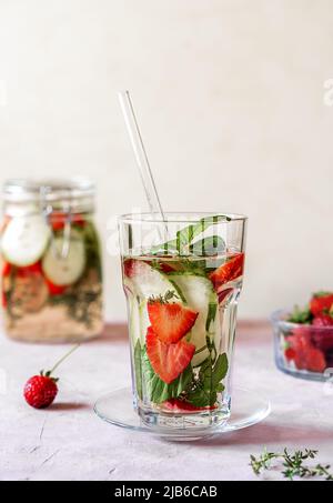 Acqua infusa con fragola e meloncella che è ibrido di cetriolo e melone, timo, menta. Spazio di copia. Foto Stock