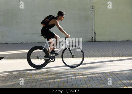 Giovane uomo in bicicletta per strada. Foto Stock