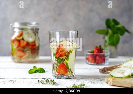 Acqua infusa con fragola e meloncella che è ibrido di cetriolo e melone, timo, menta. Foto Stock