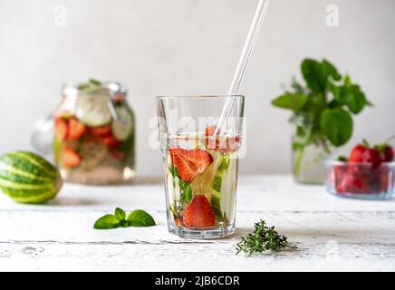 Acqua infusa con fragola e meloncella che è ibrido di cetriolo e melone, timo, menta. Foto Stock